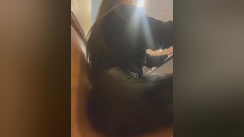 Video of a person in a black leather jacket sitting in a car, blurry due to motion, with light streaming through the windshield.