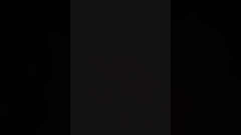 A video of a black, rectangular object against a black background, creating a stark, minimalist aesthetic. The object's texture is smooth and glossy, reflecting no light, making it blend seamlessly into the background.