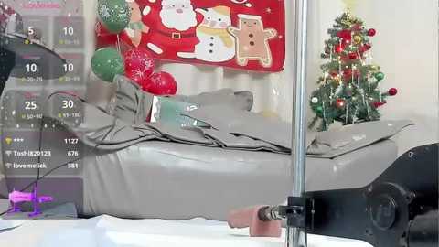 A video shows a grey recliner chair with a white blanket, decorated with Christmas ornaments, next to a lit Christmas tree. The scene has a festive, cozy ambiance.