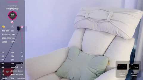 Media: Video of a white, plush recliner with a light green cushion and a folded white blanket, set against a light gray wall. The image includes a digital health monitoring app overlay displaying vital signs and sleep data.