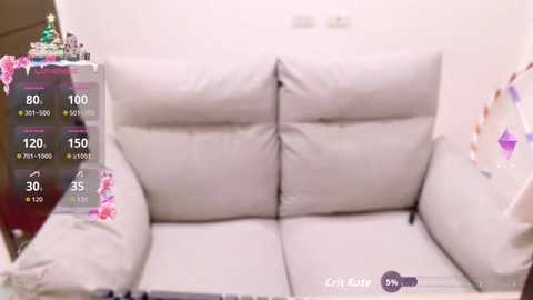 A video of a white, plush sofa with a clear overlay displaying a temperature gauge showing 80% humidity and 150% humidity. The room is minimally decorated with a white wall and a festive, colorful garland in the background.
