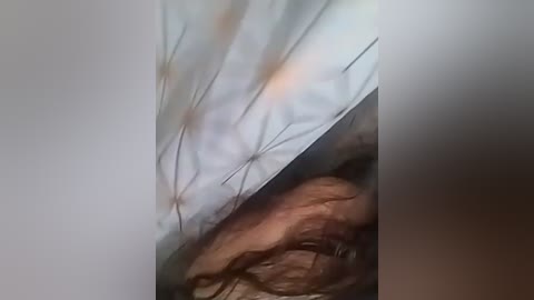 A close-up video of a person's face with a white pillowcase, showing skin texture and wrinkles, with a blurred background.