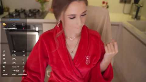 A video shows a young woman in a red satin robe, seated in a modern kitchen, wearing a necklace, with a digital overlay displaying cooking instructions.