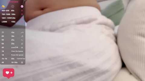A video of a person's midsection, showing a white t-shirt and part of their stomach. The image includes a side view of a smartphone with a health app displaying statistics.