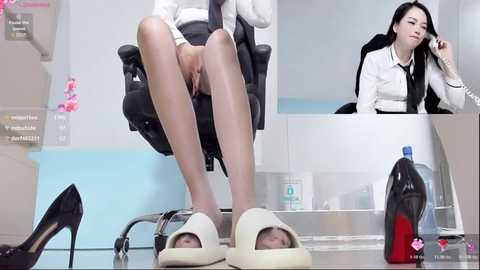 A video of an Asian woman in a white blouse and black skirt, seated in a black chair, with her legs crossed and feet in beige slippers, surrounded by scattered high heels and cleaning supplies in a white and light blue room.