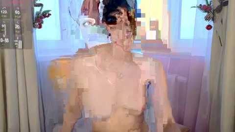 Media: Video of a topless woman with medium-sized breasts, pale skin, and dark hair styled in a bun, standing in a brightly lit room with a window, floral decorations, and a blurred background.