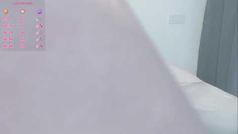 A video of a minimalist bathroom with a white bathtub, grey towel rack, and a light grey wall. The left side features a digital clock and weather display.