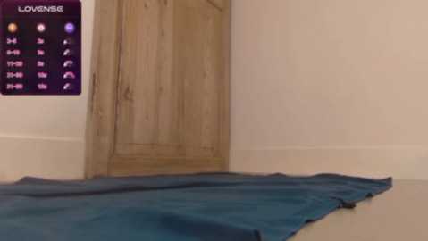 Video of a beige room with a wooden door and a blue yoga mat. A purple digital clock with a \"LOVENING\" label displays numbers and symbols.