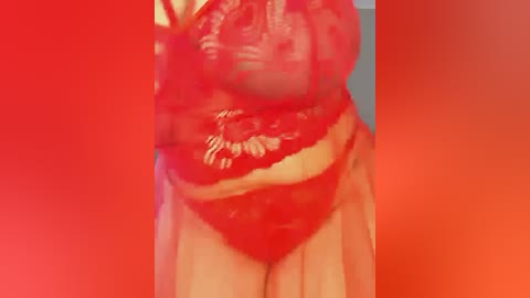 A video showing a close-up of a woman in red lace lingerie, standing against a gradient background of red to orange hues, emphasizing her curvaceous figure and the delicate texture of the fabric.