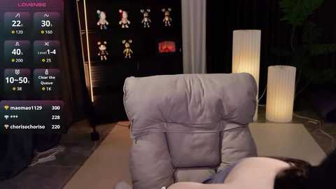 Video of a dimly lit living room with a reclining chair, a white lamp, and a TV displaying a video game.