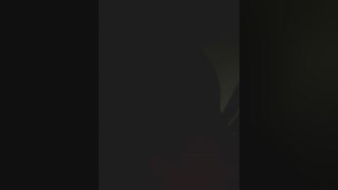 Media: This is a video featuring a dark, blurry background with a slight greenish tint, possibly indicating a nighttime or low-light setting. The image is mostly black, with indistinct shapes and a lack of clear objects or details, making it difficult to discern specific elements or subjects.