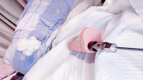 Video of a person lying in a hospital bed, covered with white sheets, wearing a light blue plaid shirt, and being administered oxygen through a clear tube inserted into their nose.