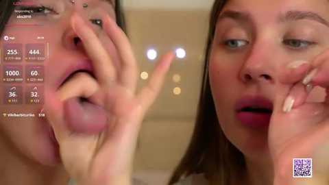 Video of a close-up of a woman's face, showing her licking a finger. Her lips are red, and she has a piercing in her nose. The background is blurred, with a screen overlay displaying facial analysis data.