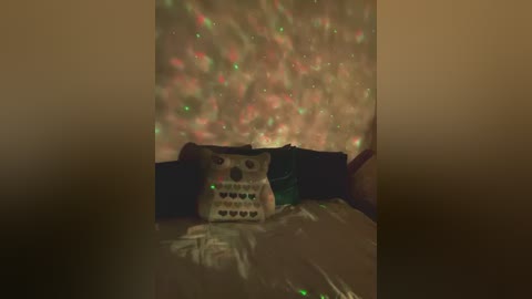 Video of a cozy, dimly-lit bedroom with a plush, patterned pillow on a bed, illuminated by soft, colorful LED light strands on the wall, creating a warm, festive atmosphere.