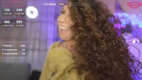 Video of a smiling woman with curly brown hair, wearing a yellow knit sweater, in a cozy indoor setting with purple lighting. Social media stats overlaid show \"Cric Rate\" at 120.0.
