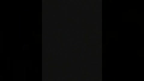 A dark, minimalist video featuring a vertical black rectangle against a pitch-black background, emphasizing contrast and simplicity. The image lacks any discernible objects or textures, focusing solely on the stark visual difference between the rectangle and the surrounding darkness.