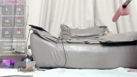 A video of a medical procedure: a person's hand is applying a compressive device to a patient's leg, which is wrapped in a gray bandage. A scale and a small purple flower are on the left.