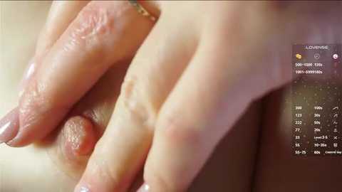 Video of a close-up of a Caucasian woman's hand with a small, raised mole on her index finger. The background shows a blurred, warm-toned setting. A smartphone screen in the right corner displays a calendar with a date of \"8/24/2017.\