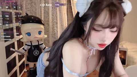 Video of an anime-style character with large eyes, wearing a maid outfit, and a cow-themed headband, leaning against a shelf filled with merchandise in a cozy room.