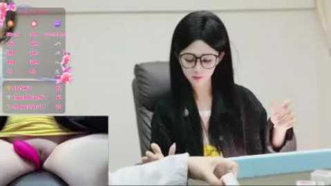 A video featuring a fair-skinned, long-haired, bespectacled Asian woman in a black jacket, seated at a desk, holding papers, with a close-up of her pink panties visible.