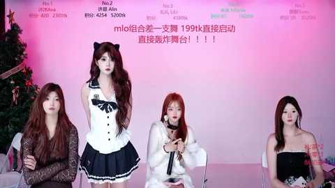 Video of four East Asian women in cosplay outfits, including a cat girl, seated on a stage with a Christmas tree in the background.