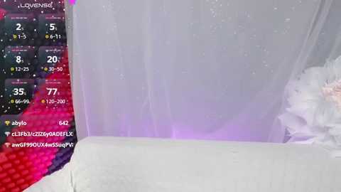 A video of a white tablecloth with a subtle gradient from white to light purple, overlaid with a transparent, glittery sheer fabric. The background features a pink and black gaming keyboard.