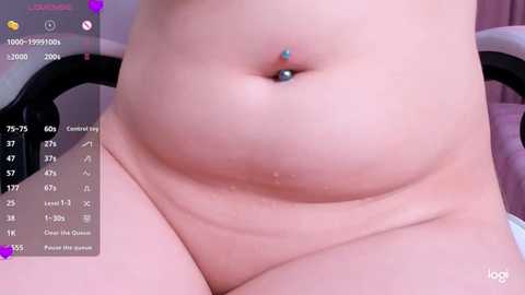 Close-up video of a fair-skinned woman's belly, showing a pierced navel with blue and turquoise jewels. The background includes a digital interface with a chat log and a list of body measurements.