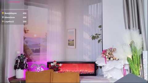 Video of a modern living room with a cozy fireplace, soft lighting, floral arrangements, and a serene sunset mural on the wall.