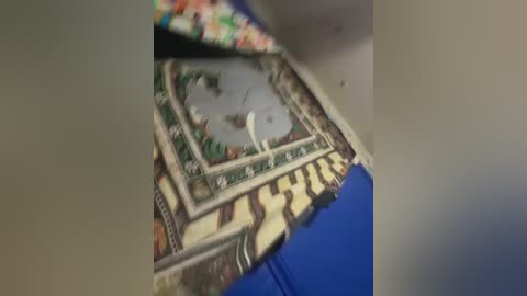 Video of a blue couch with a decorative pillow featuring a detailed, colorful geometric pattern and a large, white, seated Buddha statue.