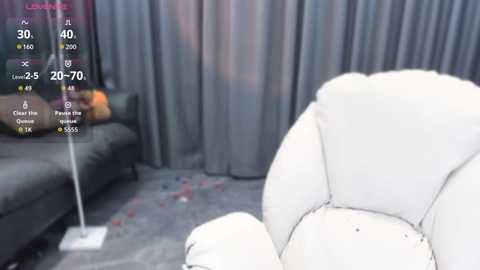 Video of a modern living room with gray curtains, a gray sofa, a white bean bag chair, and a digital display showing \"Lose\" and \"Win\" options.