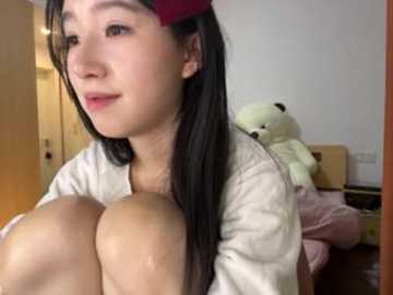 Video of an Asian woman with long black hair, wearing a red hair clip, holding her large breasts, in a cluttered bedroom with stuffed animals.