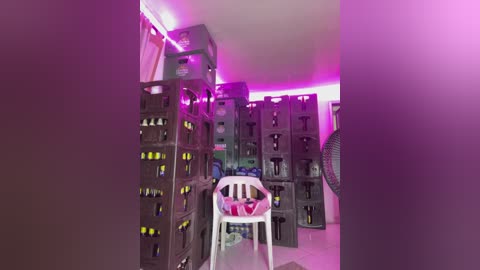 A video of a cluttered room with stacks of plastic water bottles, cardboard boxes, and a single white chair, bathed in purple and pink lighting.