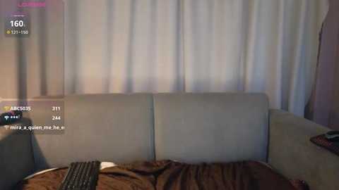 Video of a dimly lit living room with a beige sofa and white curtains, showing a video recording interface with time stamps and user comments.