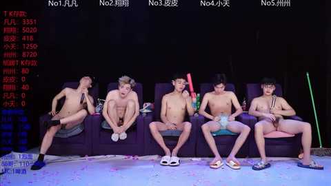 Video of six shirtless, muscular Asian men, seated on a dark couch, wearing only underwear, in a dimly lit room with a TV screen displaying \"NO4JAP\" in the background.