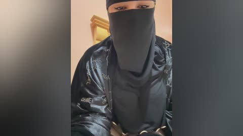 A video of a person dressed in a black Batman costume with a mask, standing indoors with a blurred background.