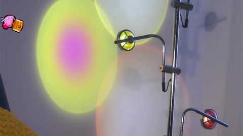 Video of a modern lamp with three colored light bulbs (yellow, green, and red) on a metal stand, set against a blurred, gray background, featuring a cartoon character in the top left corner.
