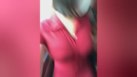 Video of a blurred woman in a red top, her face partially hidden, against a red background.