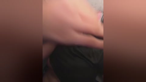 A blurred video shows two nude individuals in a sexual position, with their bodies partially obscured. The background is out of focus.