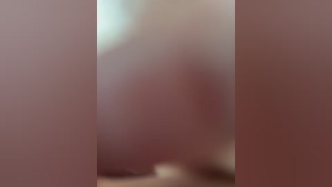 A blurry video featuring two people standing in a dimly lit room. The individuals are partially obscured by the focus blur, making it difficult to discern their gender, ethnicity, or physical features.