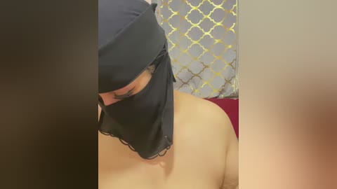 Video of a woman in a black veil and red top, partially obscured by a darkened frame on the left and blurred edges on the right.