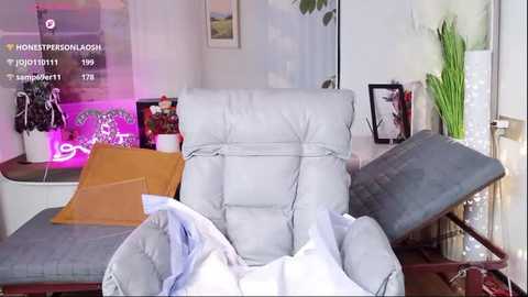 Video of a light gray leather office chair in a cluttered room with a laptop, paperwork, and decorative items on a wooden desk.