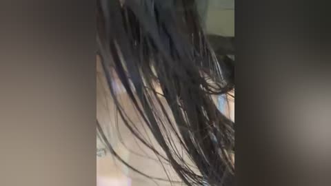 Video of a person's head with long, tangled, dark brown hair, blurred background, indistinct facial features, and out-of-focus lighting.