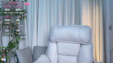 Media: Video of a modern, white leather recliner in a minimalist living room with light gray curtains and a tall, slender floor lamp.