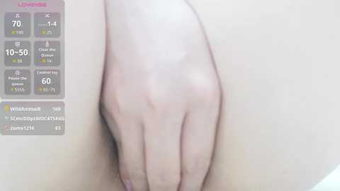 A video of a close-up view of a person's hand on their inner thigh, with a digital overlay displaying health stats. The skin is light, and the background is blurred.