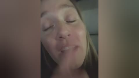 A video of a close-up, blurry face with light skin and closed eyes, with a prominent nose and mouth, framed by vertical, blurred objects on the left and right sides.