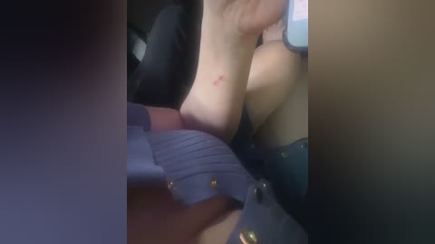 A blurry video shows a light-skinned person with medium-sized breasts, wearing black lingerie, partially visible on a bed with purple pillows.