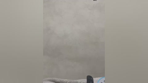 Video of a steamy bathroom with a white, foggy mirror, a black hairbrush, and a towel on the left. The background is blurred and light grey, creating a soft, diffused atmosphere.