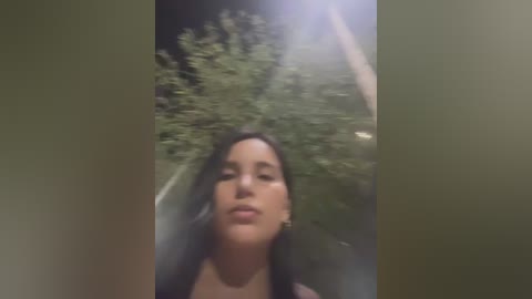 Video of a young woman with long dark hair, wearing a black top, captured through a foggy car window. She appears calm and serene. Background shows blurred greenery and a bright light source.