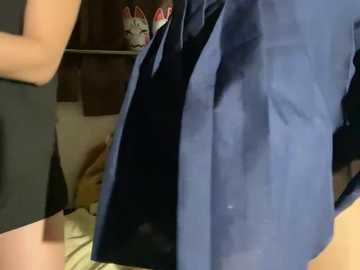 Video of a person in a blue shirt and black shorts, standing in a cluttered room with shelves and shoes in the background.