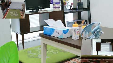 Video of a cluttered office desk with a blue Kleenex box, tissues, a can of hand sanitizer, and a glass of water. Background includes a dark wooden shelf, a computer monitor, and scattered papers.